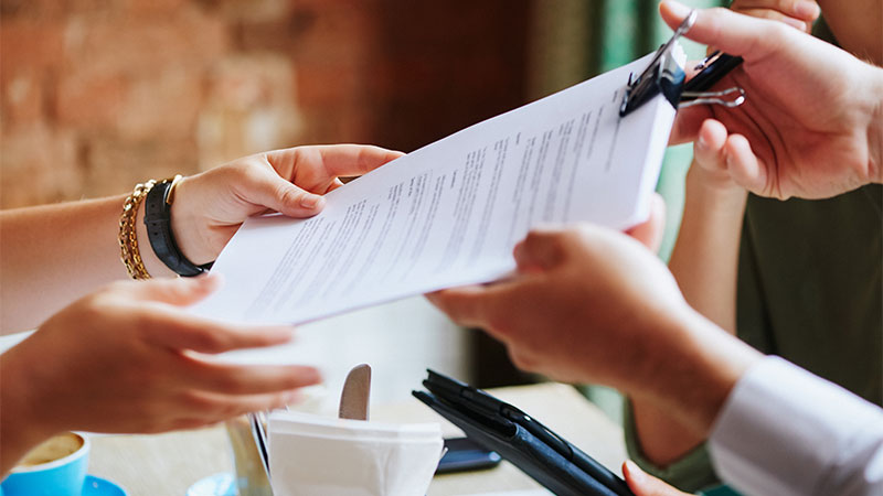 Lawyer handing over legal document at  a meeting in a cafe