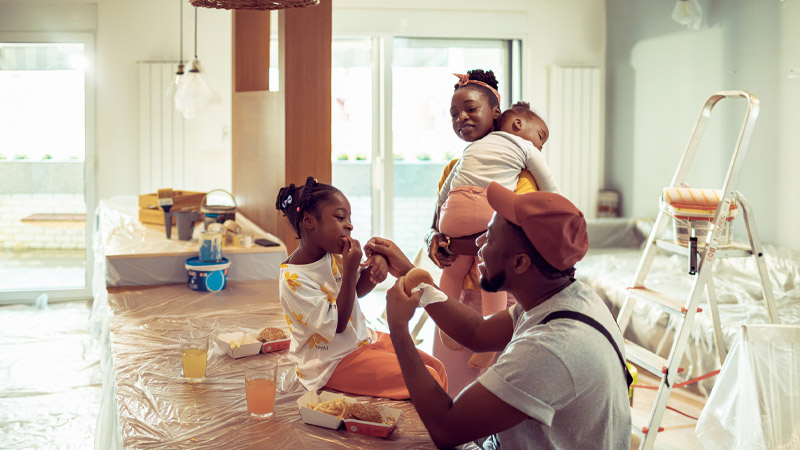 Close up of a young family having a lunch break while renovating and painting their house