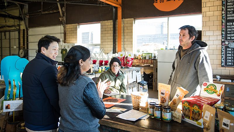 Tom Choi and Prachi Patel speak with employees at Detroit Farm and Garden, a small business located in a former, abandoned police precinct that was revitalized by Southwest Solutions.