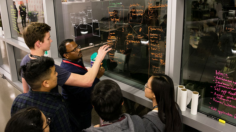 Professor writing on glass in a class room