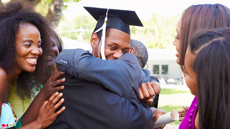496038305 African American Student Celebrates Graduation Smiling