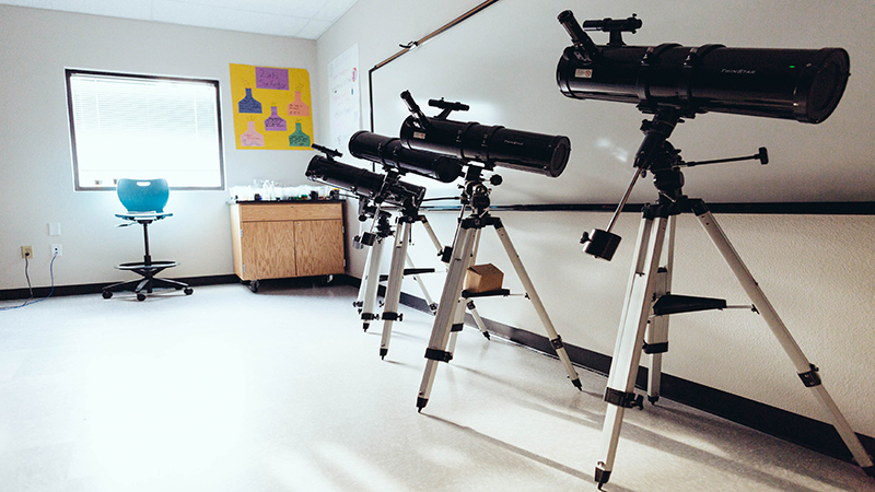 Telescopes line an NLF YET College Prep classroom, giving high school students the opportunity to explore the stars.