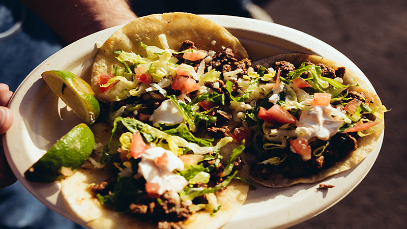 A Jamburitto customer holds up his plate of three Jambalaya-Burritos