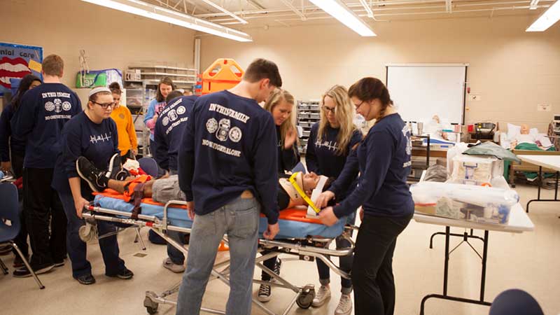Health Sciences students at Lenoir City “assess” a classmate during a car crash simulation. Health Science students at Lenoir City often learn material through hands-on role-playing activities, including mass casualty situations held on the school’s football field.